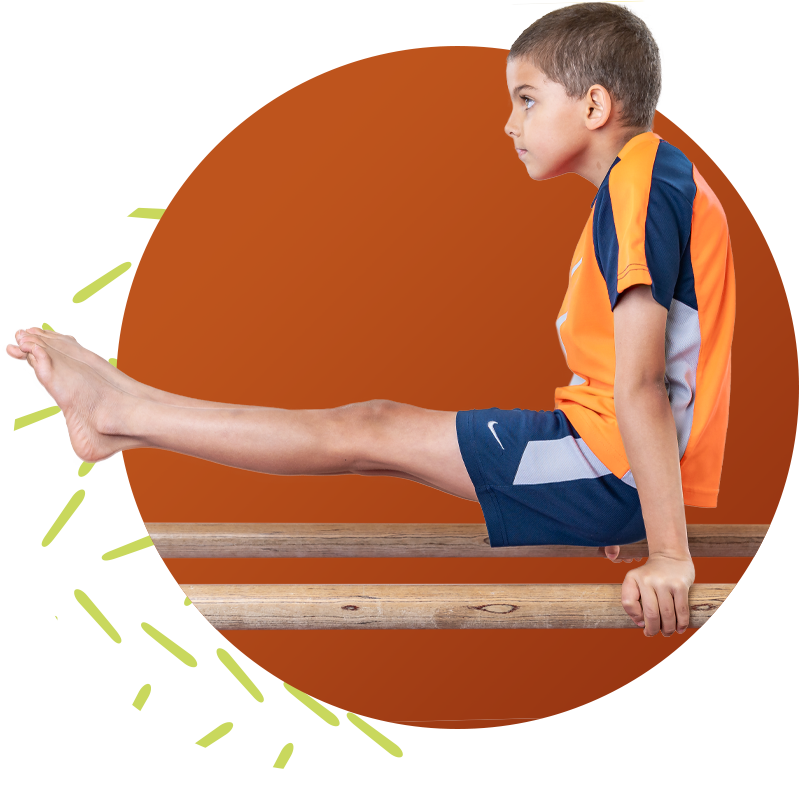 Young male gymnast lifting his legs in the air on parallel bars